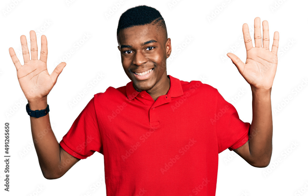 Young african american man wearing casual red t shirt showing and pointing up with fingers number ten while smiling confident and happy. Young african american man wearing casual red t shirt showing and pointing up with fingers number ten while smiling confident and happy.