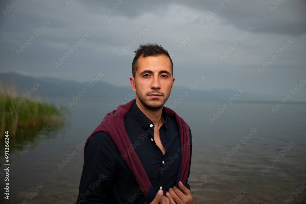 Fashion portrait of young man in black shirt and dark red jumper Fashion portrait of young man in black shirt and dark red jumper