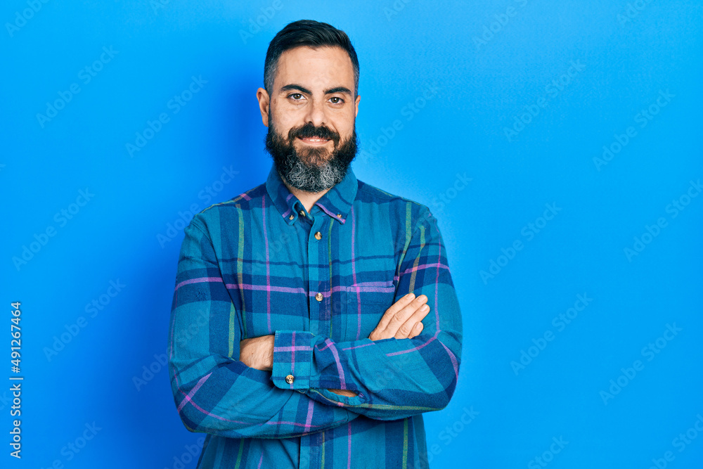 Young hispanic man wearing casual clothes happy face smiling with crossed arms looking at the camera. positive person. Young hispanic man wearing casual clothes happy face smiling with crossed arms looking at the camera. positive person.