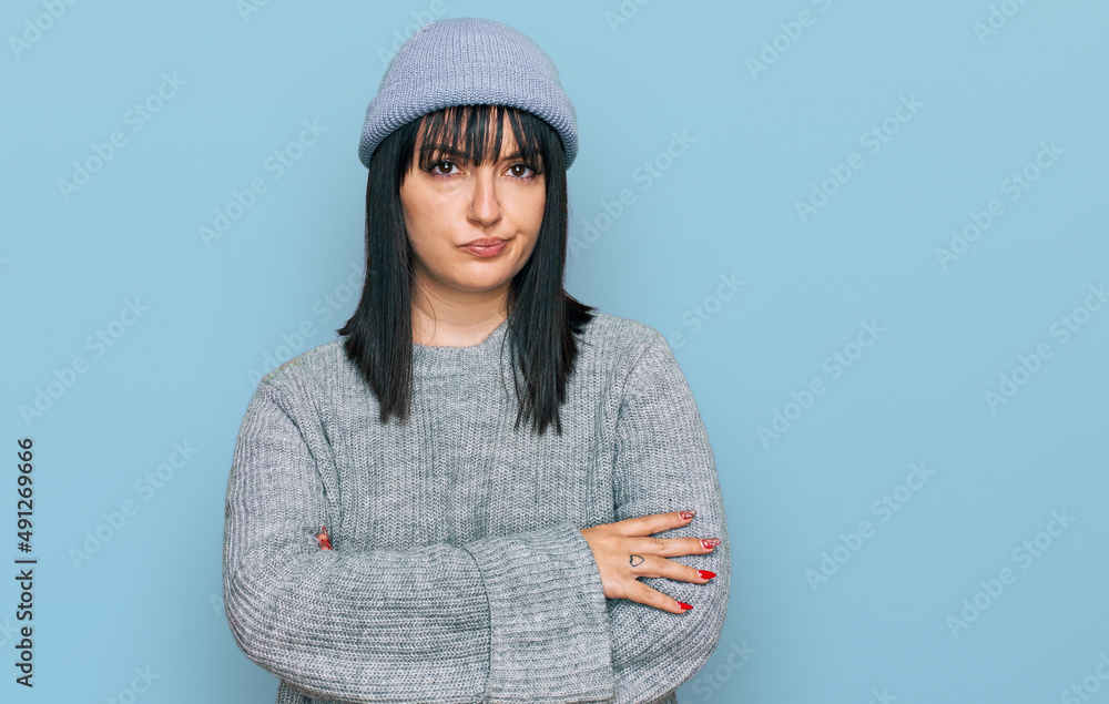 Young hispanic woman wearing cute wool cap skeptic and nervous, disapproving expression on face with crossed arms. negative person. Young hispanic woman wearing cute wool cap skeptic and nervous, disapproving expression on face with crossed arms. negative person.