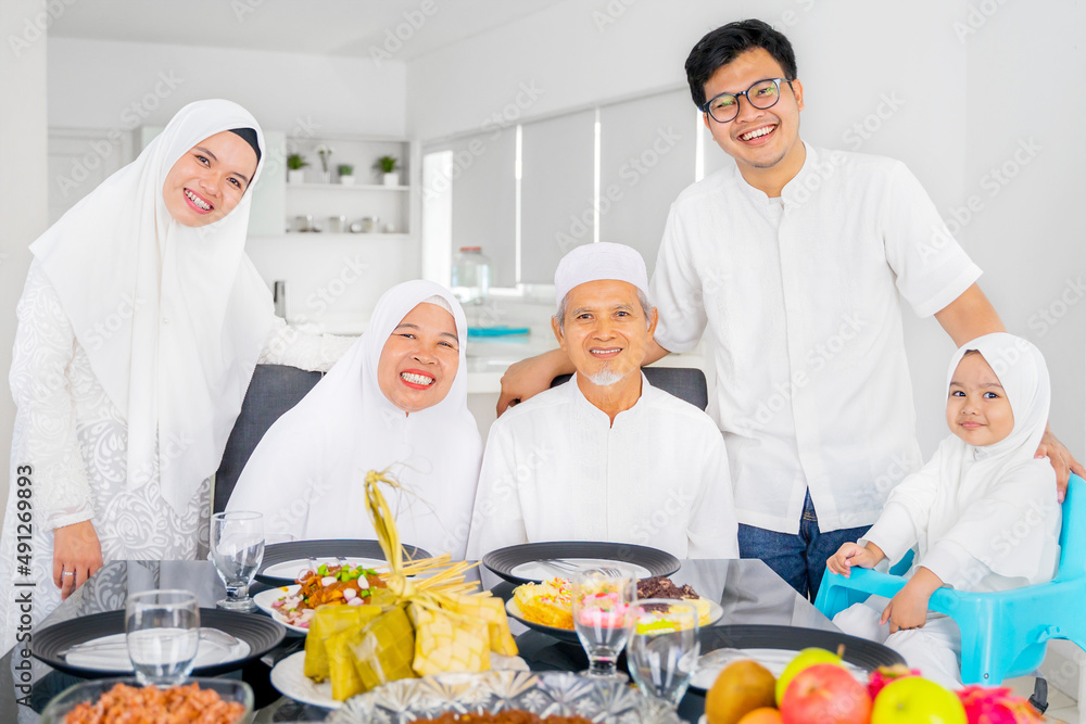 Family having meal while smile at camera during Eid