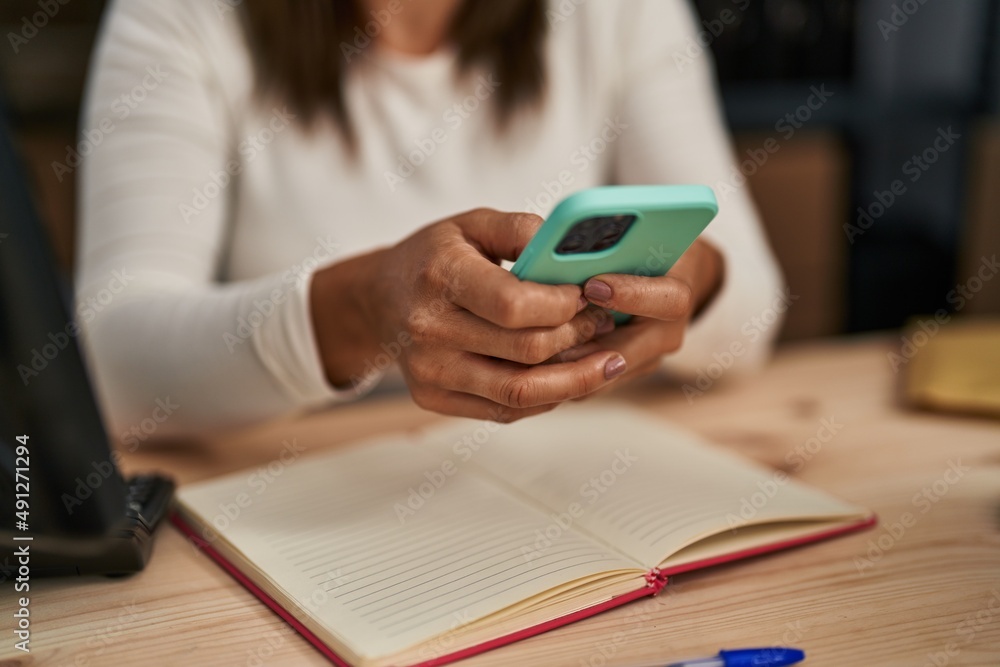 Fototapeta premium Middle age woman ecommerce business worker using smartphone at office