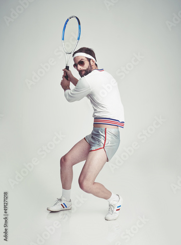 Retro fitness. A young man in the studio wearing tennis gear.