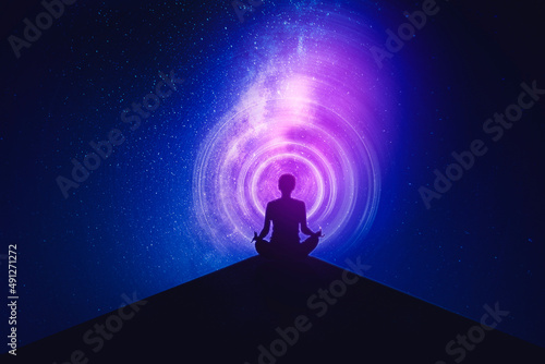 Young woman meditating with milky way background