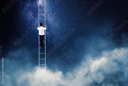 Businessman climb on ladder toward sky at night