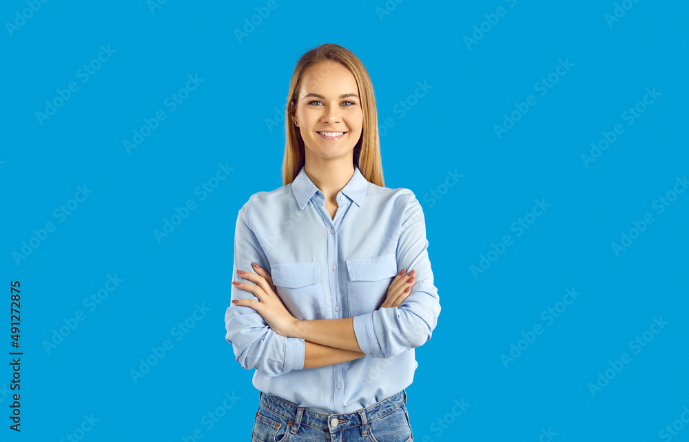 Studio portrait of a happy smiling young woman in casual clothes ...