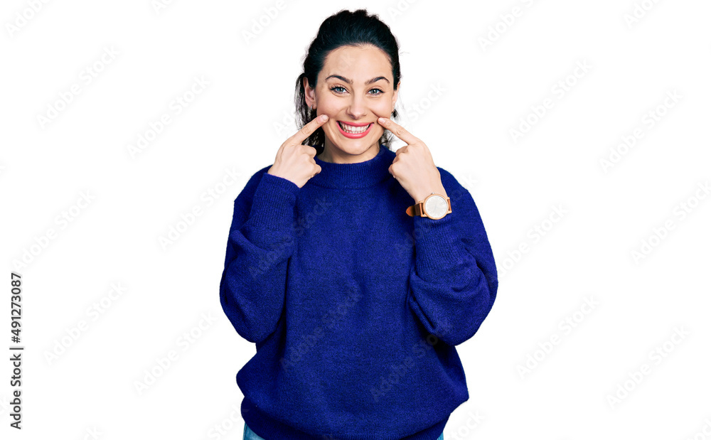 Young hispanic woman wearing casual clothes smiling with open mouth, fingers pointing and forcing cheerful smile Young hispanic woman wearing casual clothes smiling with open mouth, fingers pointing and forcing cheerful smile