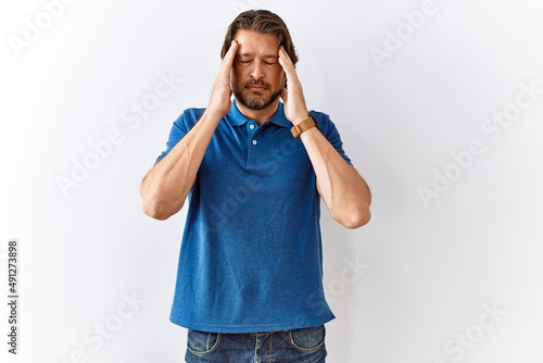 Handsome middle age man standing together over isolated background with hand on head, headache because stress. suffering migraine.