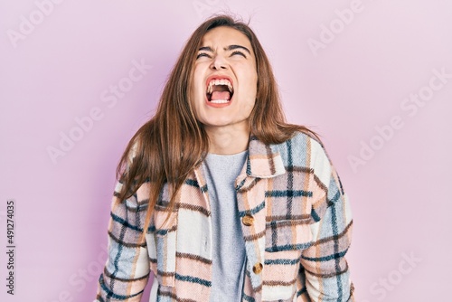 Young caucasian girl wearing casual clothes angry and mad screaming frustrated and furious, shouting with anger. rage and aggressive concept.