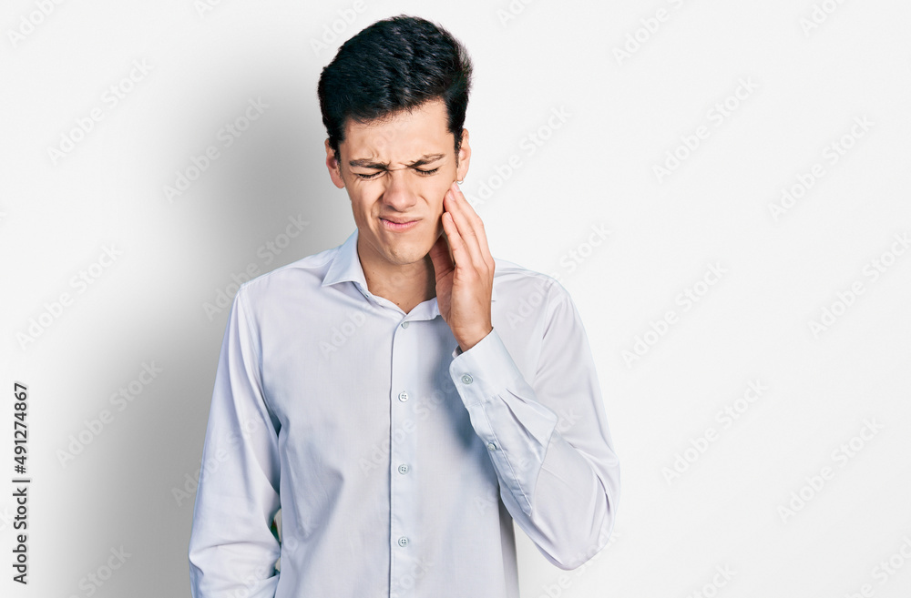 Young hispanic business man wearing business clothes touching mouth with hand with painful expression because of toothache or dental illness on teeth. dentist Young hispanic business man wearing business clothes touching mouth with hand with painful expression because of toothache or dental illness on teeth. dentist