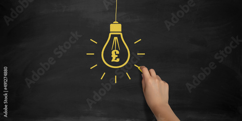 British Pound Symbol Bulb Drawing with Chalk on Blackboard by Female Hand