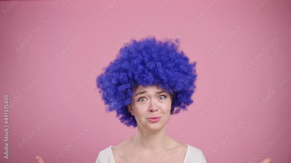 Portrait of shocked woman on pink background. Young female in blue wig has her head boiled. Portrait of shocked woman on pink background. Young female in blue wig has her head boiled.
