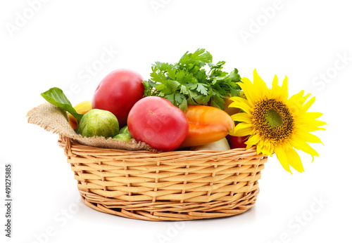 Different ripe vegetables in the cart with sunflower.