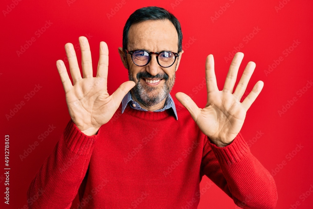 Middle age hispanic man wearing casual clothes and glasses showing and pointing up with fingers number ten while smiling confident and happy. Middle age hispanic man wearing casual clothes and glasses showing and pointing up with fingers number ten while smiling confident and happy.