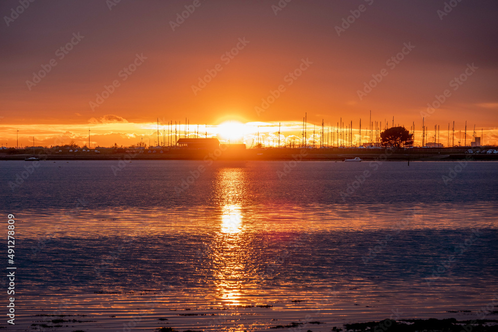 sun setting over the sea with Langstone bridge in the background