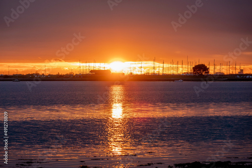 sun setting over the sea with Langstone bridge in the background photo