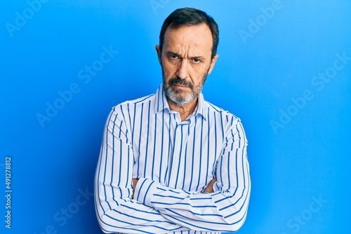 Middle age hispanic man wearing casual clothes skeptic and nervous, disapproving expression on face with crossed arms. negative person.