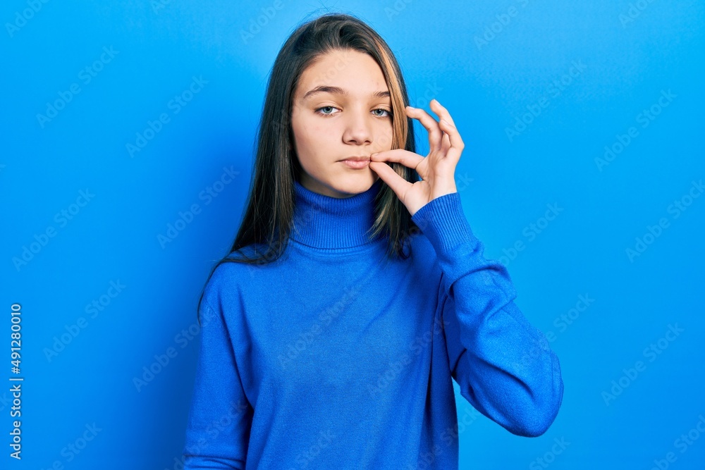 Young brunette girl wearing turtleneck sweater mouth and lips shut as zip with fingers. secret and silent, taboo talking Young brunette girl wearing turtleneck sweater mouth and lips shut as zip with fingers. secret and silent, taboo talking