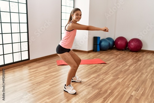 Adorable girl smiling confident stretching at sport center