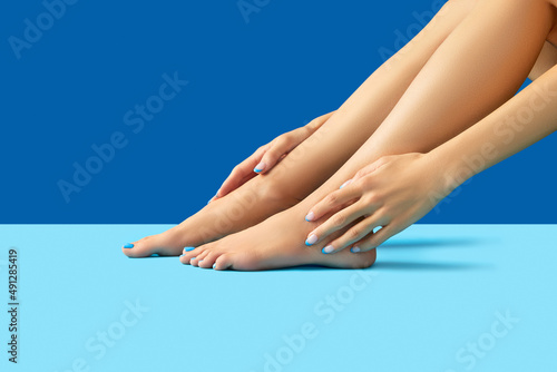 Female legs and hands with fashionable blue nail design