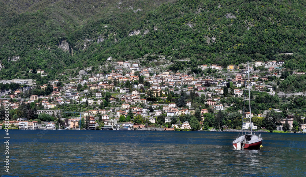 Vista de Como (Italia) desde el lago con un yacht en primer plano y al fondo cientos de casas en las colinas.