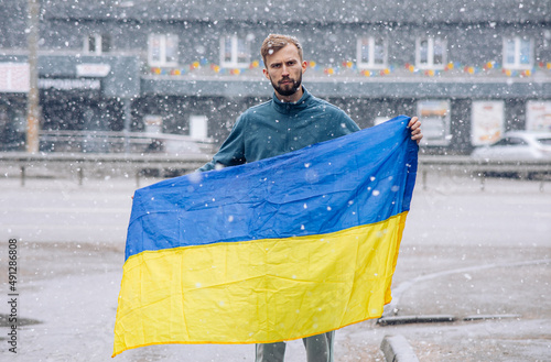 Angry man holds ukrainian flag in his hands and protests against Russia attack to Ukraine. photo