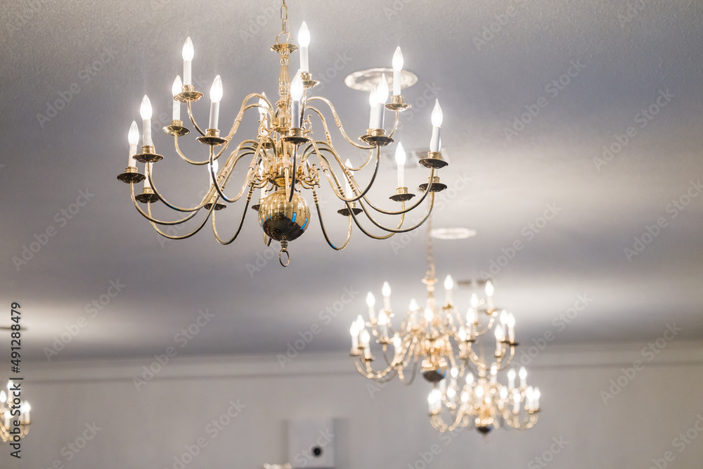 Several candelier lights hanging from a white ceiling to illuminate a room Several candelier lights hanging from a white ceiling to illuminate a room