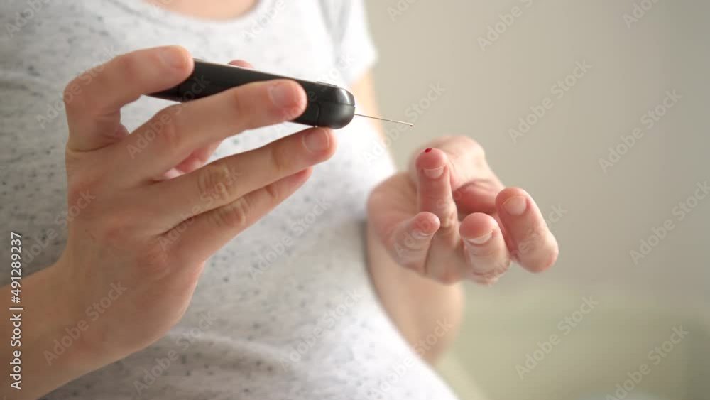 Pregnant woman holding glucose meter and checking sugar level. Concept of diabetes during pregnancy. Healthcare control. Diabetes checking blood sugar. Pregnant woman holding glucose meter and checking sugar level. Concept of diabetes during pregnancy. Healthcare control. Diabetes checking blood sugar.