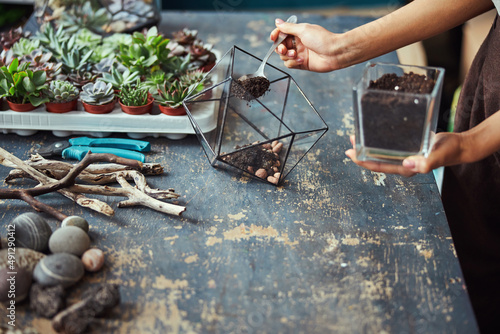 Foto Florist filling a terrarium container with the potting mix