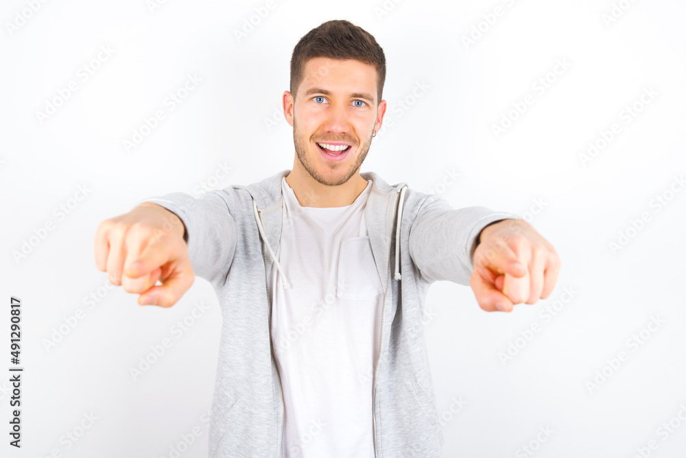 Close-up portrait of surprised young caucasian man wearing casual clothes over white background pointing with two fingers to the camera saying: I choose you!, looking up with open mouth. Close-up portrait of surprised young caucasian man wearing casual clothes over white background pointing with two fingers to the camera saying: I choose you!, looking up with open mouth.