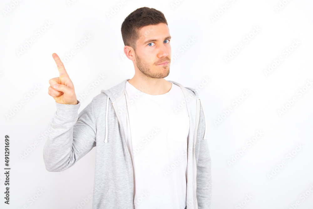 No sign gesture. Closeup portrait unhappy young caucasian man wearing casual clothes over white background raising fore finger up saying no. Negative emotions facial expressions, feelings. No sign gesture. Closeup portrait unhappy young caucasian man wearing casual clothes over white background raising fore finger up saying no. Negative emotions facial expressions, feelings.