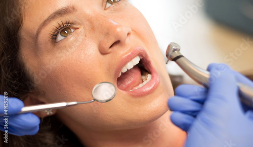 Young woman checking her teeth at the dentist clinic.