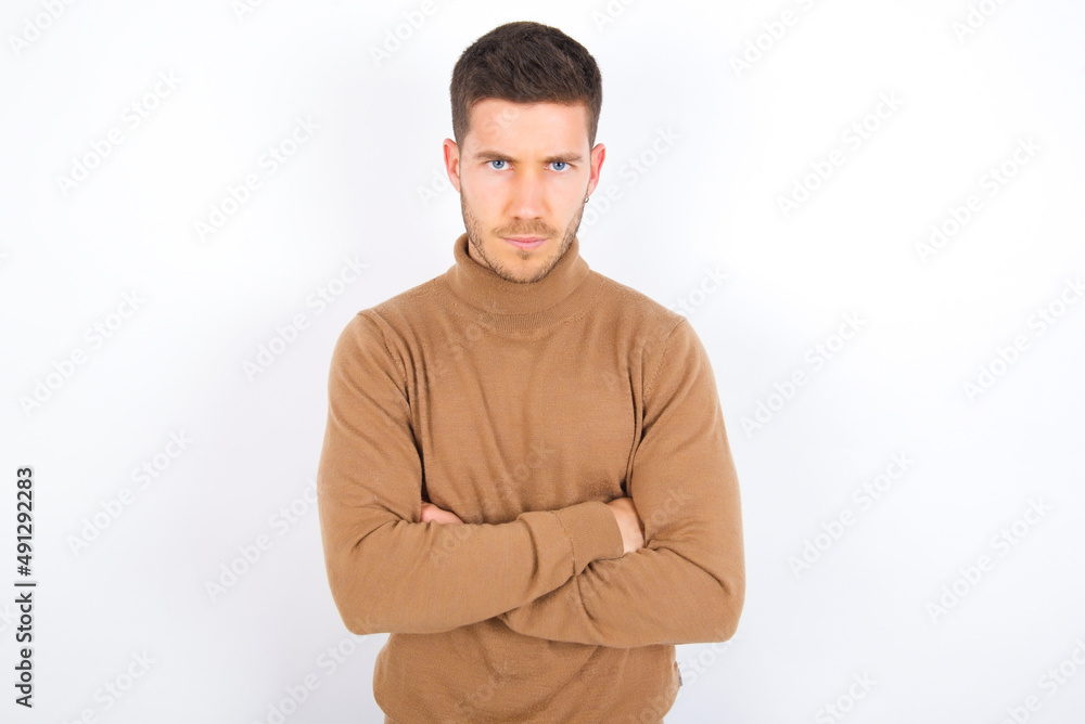 young caucasian man wearing knitted turtleneck over white background Pointing down with fingers showing advertisement, surprised face and open mouth young caucasian man wearing knitted turtleneck over white background Pointing down with fingers showing advertisement, surprised face and open mouth