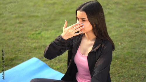 Young indian girl doing yoga, girl doing anulom vilom early in the morning in park. Healthy lifestyle concept. photo