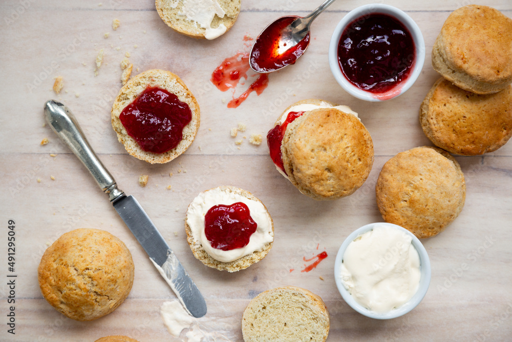 Delicious british scones with strawberry jam and clotted cream - obrazy, fototapety, plakaty 