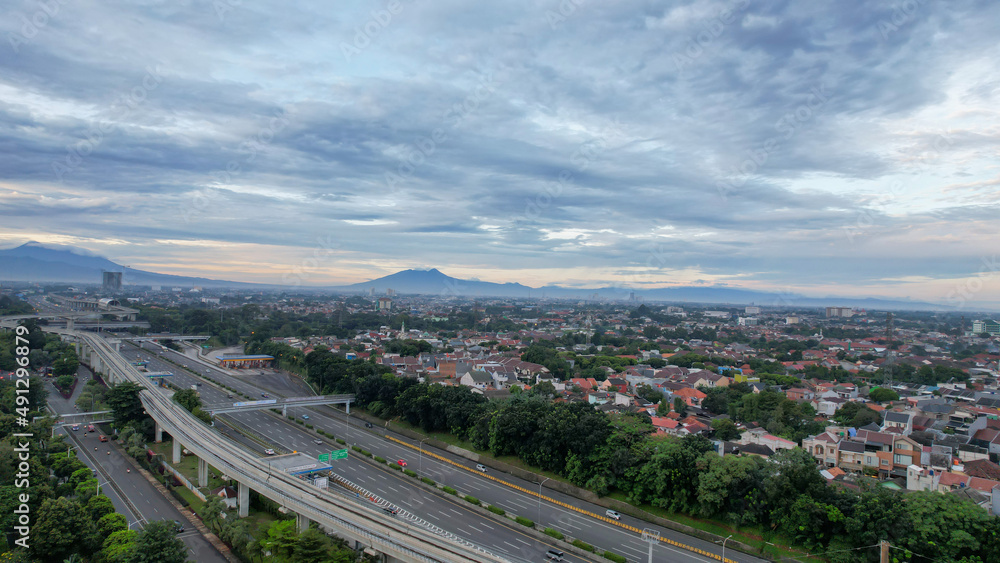 Aerial view of quiet traffic on Taman Mini street with mountain view during weekend in Jakarta city. Jakarta, Indonesia, March 8, 2022