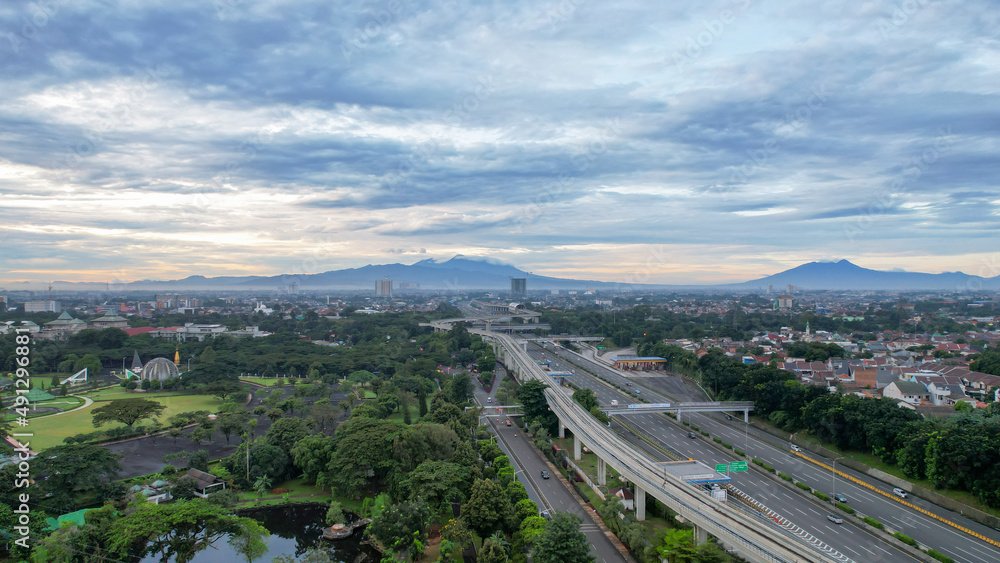 Aerial view of quiet traffic on Taman Mini street with mountain view during weekend in Jakarta city. Jakarta, Indonesia, March 8, 2022