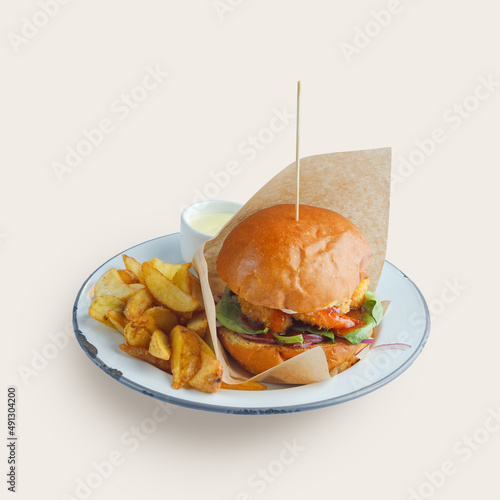appetizing burger traditional serving on a plate with sauce and fried potatoes