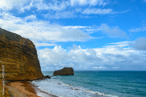 Layered Rock by the ocean  beautiful ocean view  beautiful sky with white clouds