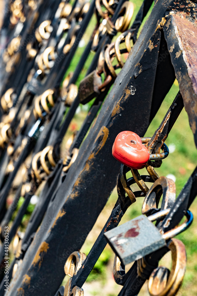 Traditional wedding locks for good luck hang on the railing of the bridge in the city Park on a Sunny summer day Traditional wedding locks for good luck hang on the railing of the bridge in the city Park on a Sunny summer day