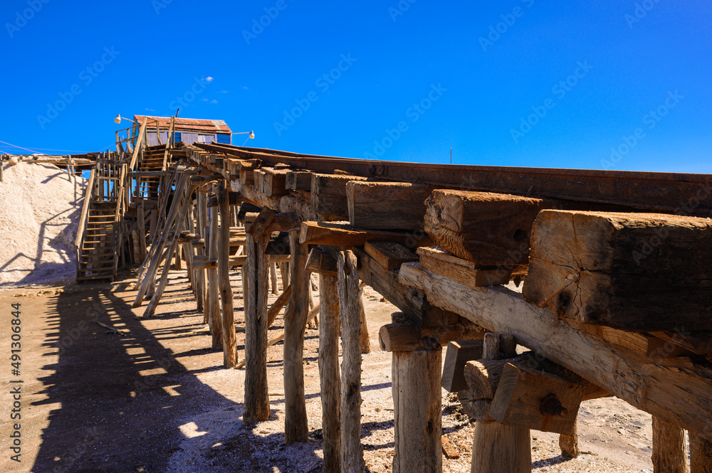 Vintage railway. Old rails at a salt factory. Mountain of sea salt. Blue sky.
