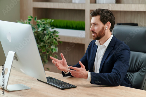 Fotografie Representive practitioner leads online training wearing a suit and headset, with