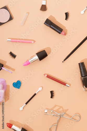 Different types of makeup on a cream background. Fashion cosmetics concept. Aesthetic wallpaper.