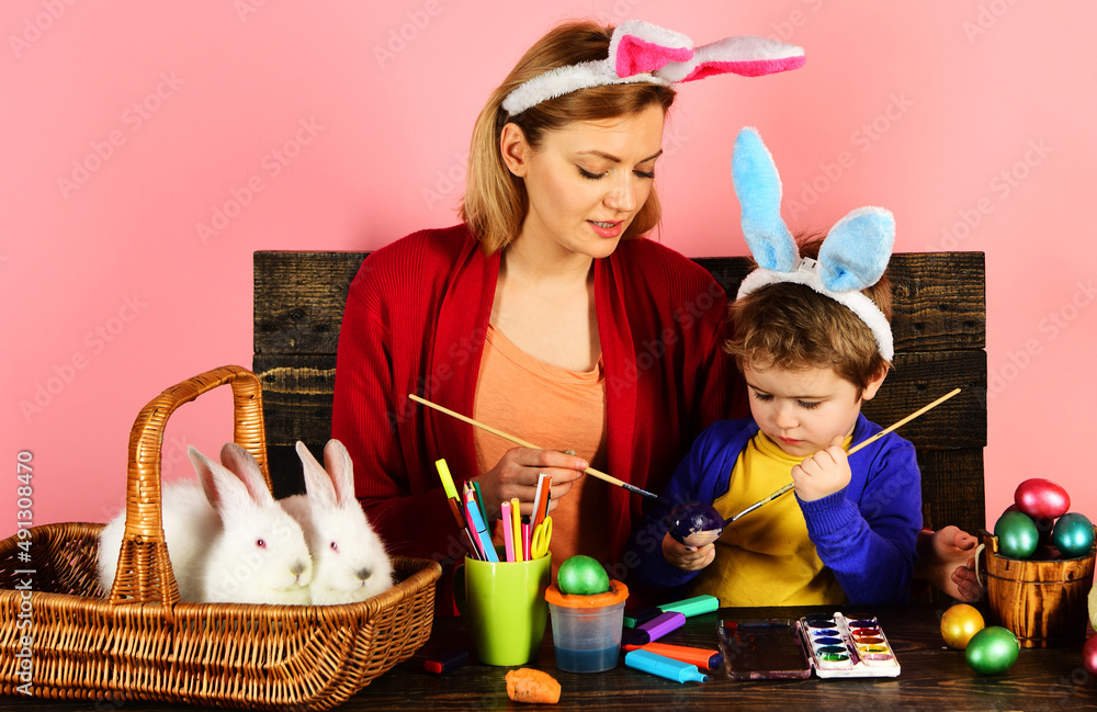 Mother and son painting Easter eggs. Happy Rabbit family with bunny ears. Egg decorating. Mother and son painting Easter eggs. Happy Rabbit family with bunny ears. Egg decorating.