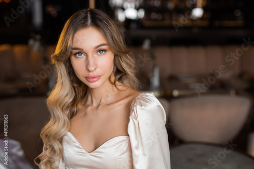 portrait of a beautiful young woman with makeup and hairstyle in a dress 