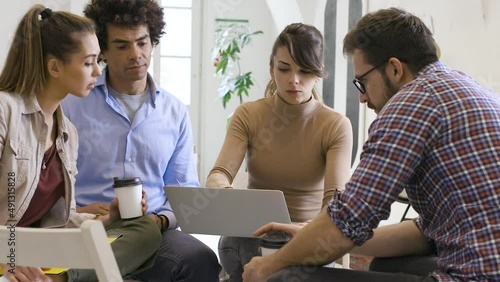 Group of casually dressed young coworkers on meeting discussing ideas at the office about new startup project.	
