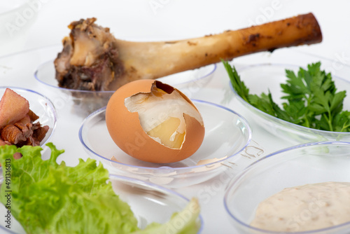Seder Plate egg close-up with shank bone on transparent plate with white background