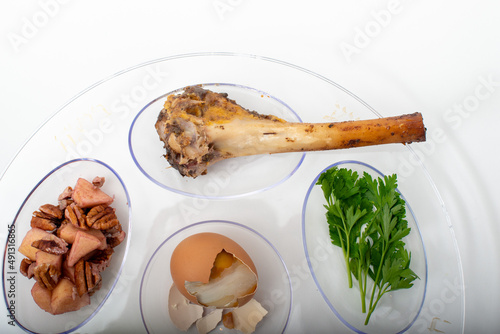 Seder Plate transparent top-down close-up view of shankbone, egg and parsley, on white background photo