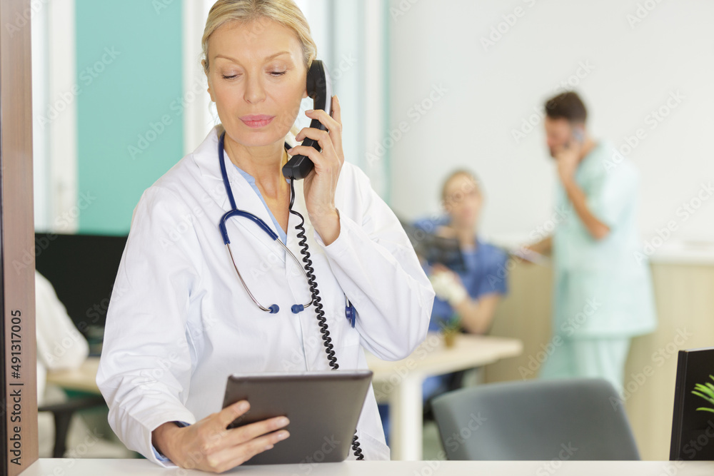 attractive mature smiling female doctor on the phone attractive mature smiling female doctor on the phone