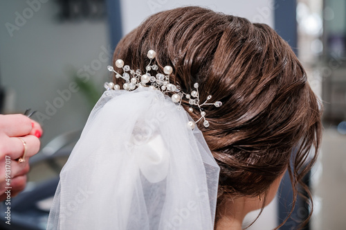 The morning of the bride. Girl makes a stylish hairstyle, a friend helps the bride, a beautiful hair ornament, preparation for a party, close-up hairstyle. Wedding